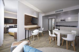 a room with a bed and a table and chairs at Fiesta Inn Ciudad del Carmen Puente El Zacatal in Ciudad del Carmen +13 photos