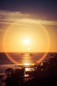 un coucher de soleil sur l'océan avec des bateaux dans l'eau dans l'établissement Fiesta Inn Ciudad del Carmen Puente El Zacatal, à Ciudad del Carmen