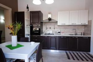 a kitchen with black and white cabinets and a table at Villa Concita in Noto