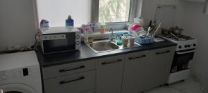 a small kitchen with a sink and a microwave at Twins Residence 2 APART HOTEL Ap 3 2 rooms in Chiajna