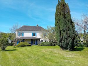 a large white house with a large yard at Bel appartement de plein pied avec jardin privé in Moncayolle-Larrory-Mendibieu