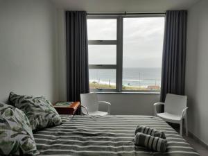 a bedroom with a bed and a view of the ocean at Peacehaven's Finest View 107 in Scottburgh +24 photos