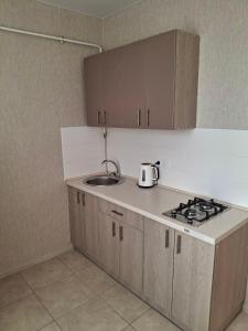 - une cuisine avec évier et bouilloire sur le comptoir dans l'établissement Апартаменты на Седьмом Небесне, à Odessa 3 autres photos