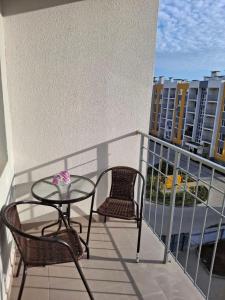 d'un balcon avec une table en verre et deux chaises. dans l'établissement Апартаменты на Седьмом Небесне, à Odessa