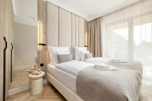 ein Schlafzimmer mit einem großen Bett und einem großen Fenster in der Unterkunft GREENERI PARK - Ambria Apartments in Świnoujście