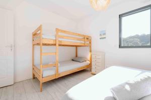 a bedroom with a bunk bed with a ladder at Maison récente, plages et commerces à pied in Jullouville-les-Pins