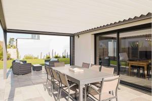 a dining room with a table and chairs on a patio at Maison récente, plages et commerces à pied in Jullouville-les-Pins +25 photos