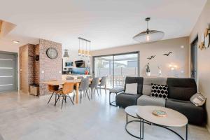 a living room with a couch and a table at Maison récente, plages et commerces à pied in Jullouville-les-Pins