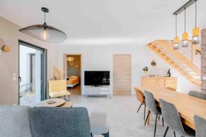 a dining room and living room with a table and chairs at Maison récente, plages et commerces à pied in Jullouville-les-Pins