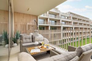 einen möblierten Balkon und ein großes Gebäude in der Unterkunft GREENERI PARK - Ambria Apartments in Świnoujście