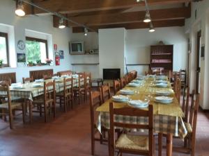 AmandolaにあるRifugio Garullaの大きなダイニングルーム(長いテーブルと椅子付)