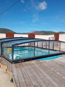 a swimming pool with a glass roof on a deck at La maison multicolore in Livron-sur-Drôme