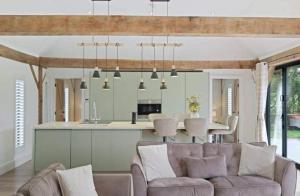 a living room with a couch and a kitchen with a table at Cedar Barn Getaway 3 Bed Sleeps 6 Parking in Bromsgrove