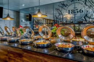 a buffet line with bowls of food and a clock at Grand Fiesta Americana Monterrey Valle in Monterrey