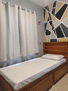 una camera da letto con un letto con lenzuola bianche e una finestra di Bali Residences a Agus