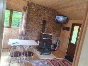 a room with a table and chairs and a television at Cabana doi mesteceni in Drumu Carului
