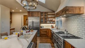 a kitchen with stainless steel appliances and wooden cabinets at Lansdowne Chateau in Breckenridge +26 photos