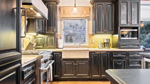 a kitchen with black cabinets and a window at Linksview Chalet North in Vail +29 photos