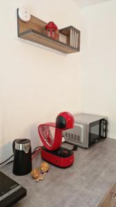a red mixer on a counter next to a microwave at Closca Apartment 2 in Floreşti