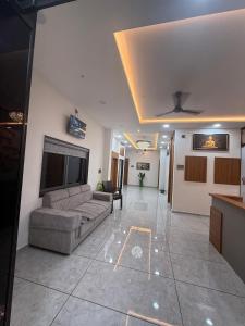 a living room with a couch and a tv at Hotel Sunrise in Ādkot
