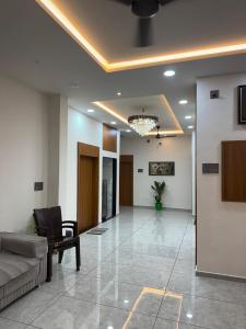 a living room with a couch and a chair at Hotel Sunrise in Ādkot