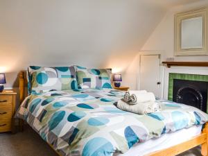 une chambre avec un lit et une cheminée dans l'établissement Needle Cottage, à Cullen