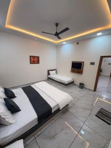 a bedroom with two beds and a ceiling at Hotel Sunrise in Ādkot