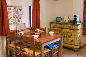 una sala da pranzo con tavolo e sedie in legno di Au Pied Du Château - Wifi Parking a Saint-Pierre-dʼAlbigny
