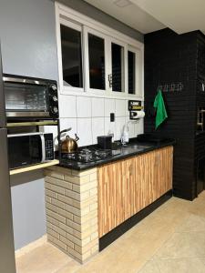 a kitchen with a counter top and a microwave at Studio com piscina e garagem Conforto e fácil acesso BR-101-Petfriendly, 2º andar in Joinville