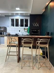 a kitchen with a wooden table and two chairs at Studio com piscina e garagem Conforto e fácil acesso BR-101-Petfriendly, 2º andar in Joinville +29 photos