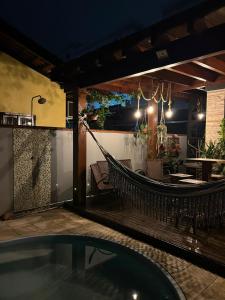 un patio avec un hamac et un restaurant le soir dans l'établissement Studio in Joinville, piscina - Pet Friendly, à Joinville