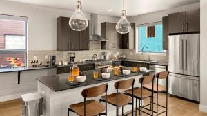 a kitchen with a large island with bar stools at Metropolitan House in Steamboat Springs