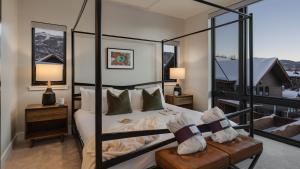a bedroom with a four poster bed and a balcony at Metropolitan House in Steamboat Springs +18 photos