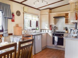 a kitchen with a table and a counter top at Woodpecker Lodge - Uk49149 in Little Singleton +9 photos