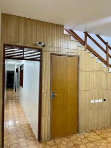 a hallway with a wooden door and a staircase at Caminho da promessa 02 centro ar cozinha in Juazeiro do Norte