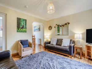 a living room with a couch and two chairs at Cairnie View in Aviemore