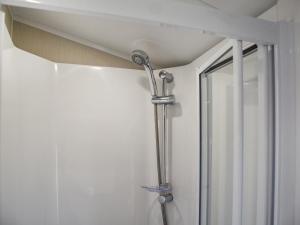 a shower in a bathroom next to a window at Kee Holiday Home in Scratby +11 photos