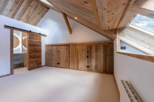 Cette chambre mansardée est dotée de murs en bois et d'un plafond voûté. dans l'établissement Grand appartement luxueux au milieu des montagnes, à Glières-Val-de-Borne