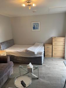 Un dormitorio con una cama, un sofá y una mesa. en Latchmead, en Little Hallingbury