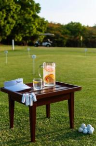 a wooden table with a drink on top of a field at PremierStays in Mombasa