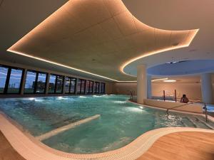 a large swimming pool in a building at Pinea Apartments in Pobierowo