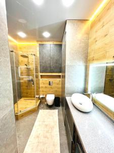 a bathroom with a sink and a shower and a toilet at Квартира 17-23 in Aktau