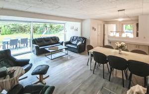 a living room with a couch and a table and chairs at Awesome Home In Oksbøl With Kitchen in Oksbøl