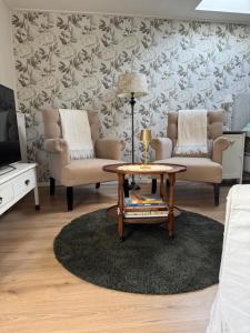Una sala de estar con dos sillas y una mesa de café. en De kleine Bongerd -The little Orchard, en Hengelo