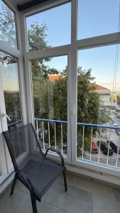 a black chair sitting on a balcony with windows at Quarto na Cova da Piedade in Almada