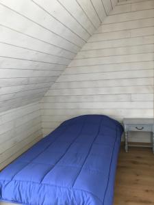 a blue bed in a white room with a table at Maison "L' Ostal De Montanha" in Génos +6 photos