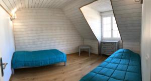 a room with two blue beds in a attic at Maison "L' Ostal De Montanha" in Génos