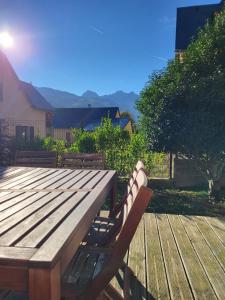 a wooden table and two benches sitting on a deck at Maison "L' Ostal De Montanha" in Génos