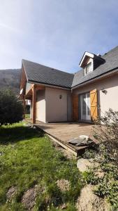 a house with a large porch and a yard at Maison "L' Ostal De Montanha" in Génos
