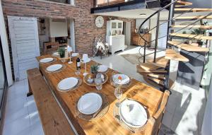 a wooden table with plates and wine glasses on it at Gorgeous Home In Paimpol With Wifi in Paimpol